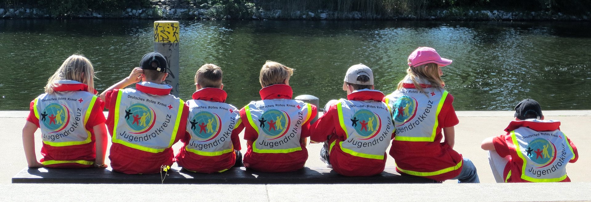 Die Kinder sitzen am Ufer